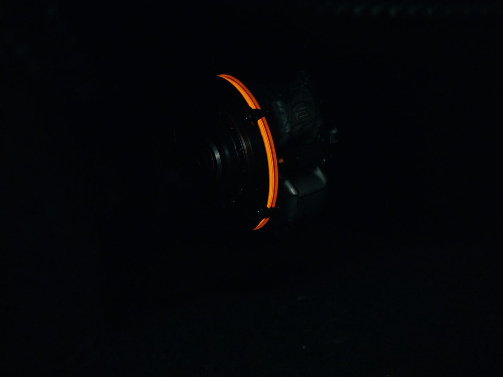 Brake disc glowing faintly orange in a dark garage